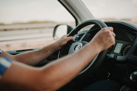 MALAGA, SPAIN - May 11, 2018: Man holding Volkswagen Transporter steering wheel while driving with a...