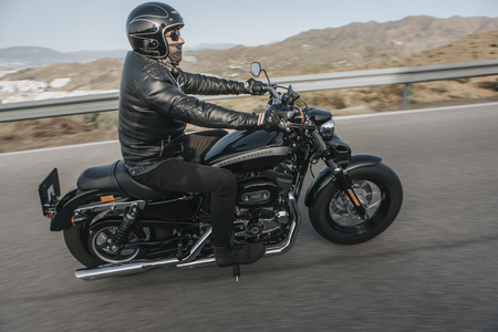 Malaga, Spain - July 15, 2018: Man riding his Harley Davidson motorcycle during a journey trip around Malaga mountain roads in Spain.のeditorial素材