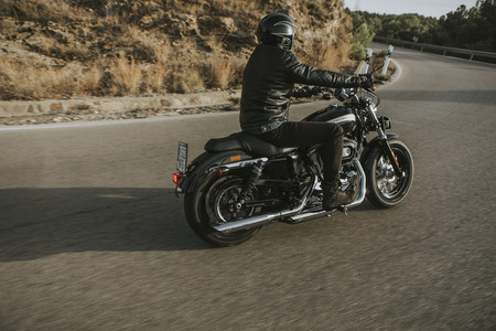 Malaga, Spain - July 15, 2018: Man riding his Harley Davidson motorcycle during a journey trip around Malaga mountain roads in Spain.のeditorial素材