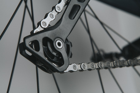 Detail of bicycle rear derailleur shifting arm with silver chain.の写真素材