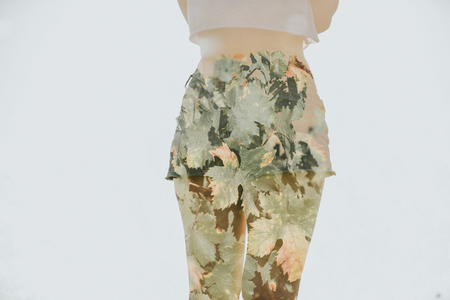 Cool double exposure of woman bum in shorts mixed with plant leaves.の写真素材