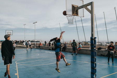 BRIGHTON, ENGLAND - October 24th, 2018: Young people playing basketball at the courts placed on the...