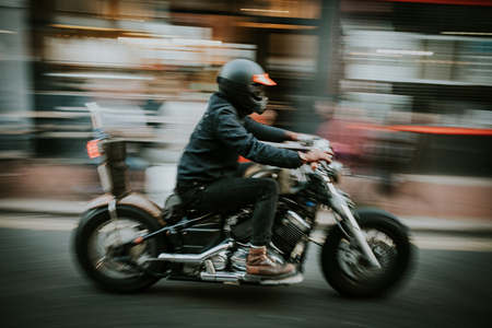 Blurry motion of man riding a motorcycle in the street.の写真素材