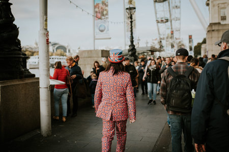 LONDON, ENGLAND - 25th October, 2018: Man wearing a suit full of Great Britain flags, while walking between the crowd in London, United Kingdom.のeditorial素材