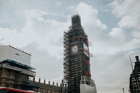 LONDON, ENGLAND - 25th October, 2018: Big Ben clock with Scaffolds, during restoration works, with sun and clouds in the background, in London, England.のeditorial素材