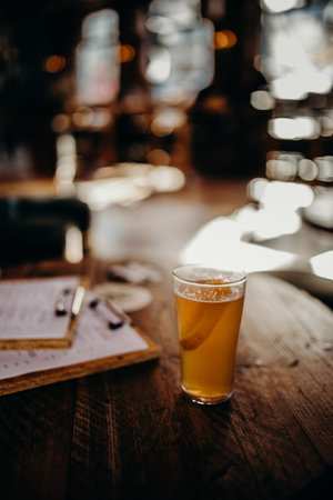 Half pint of beer in a wooden table in an english pub.