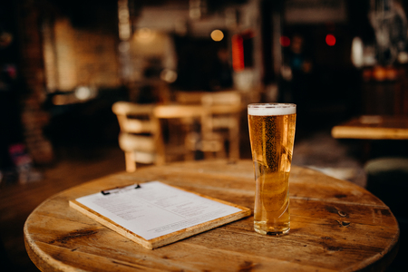 A pint of beer on a wood table at the Irish Pub.の写真素材