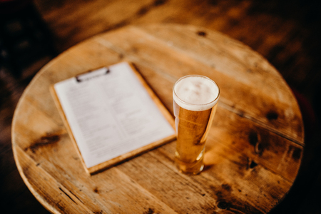 Close up of beer pint on a wooden table.の写真素材