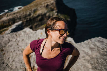 Happy natural woman portrait, with sunglasses, enjoying outdoors in the coast.の写真素材
