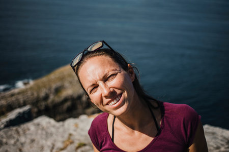 Cute friendly face woman portrait looking at camera, in the coastline.の写真素材
