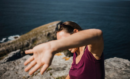 Playful woman trying to hide from photographer camera to avoid pics.