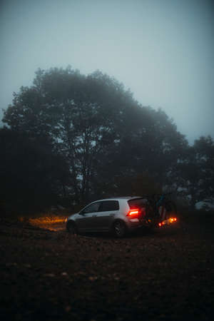 Asturias, Spain - September 9th 2020: A Volkswagen Golf VII, with mountain bikes in the back, being driven by a mountain path, with misty light, and entering into the forest, in Asturias mountain range, Spain.のeditorial素材