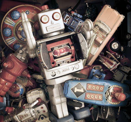 big silver robot in a pile of old toys の写真素材