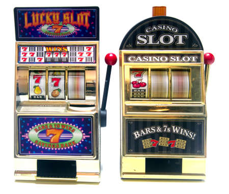 two vintage toy slot machines with gold moneyの写真素材