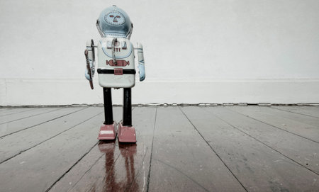 vintage robot toy standing on a wooden floor with copy spaceの写真素材