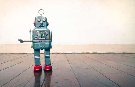 vintage robot toy standing on a wooden floor with copy spaceの写真素材