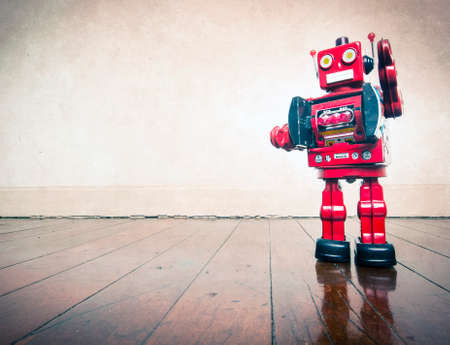 vintage robot toy standing on a wooden floor with copy spaceの写真素材