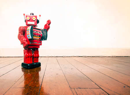 vintage robot toy standing on a wooden floor with copy spaceの写真素材