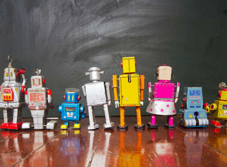 A  line of robot toys looking at a blackboardの写真素材