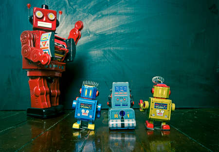 Big red robot teacher and his small robot toy studentsの写真素材