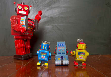 Big red robot teacher and his small robot toy studentsの写真素材