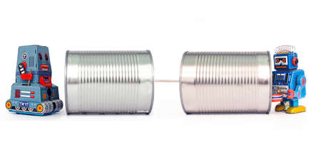 two retro robots talk on tin can phones の写真素材
