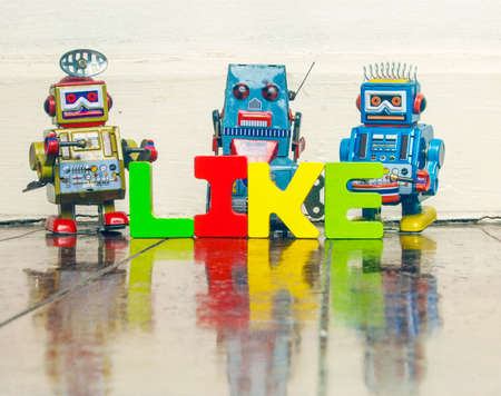 the word LIKE with retro robot toys on old wooden floor with reflectionの写真素材
