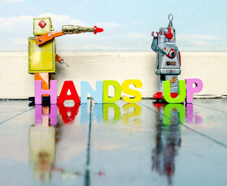 Hands up your money or your life robot toys play on a old wooden floor with text の写真素材