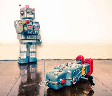 shot down concept with retro tobot toys on a wooden floor with reflectionの写真素材
