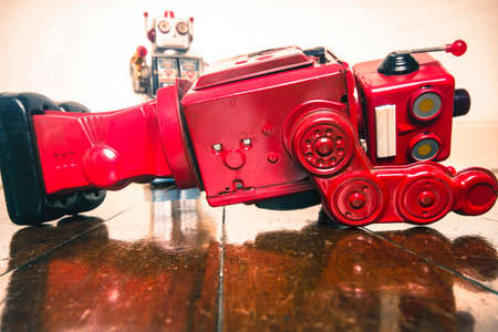 shot down concept with retro tobot toys on a wooden floor with reflectionの写真素材
