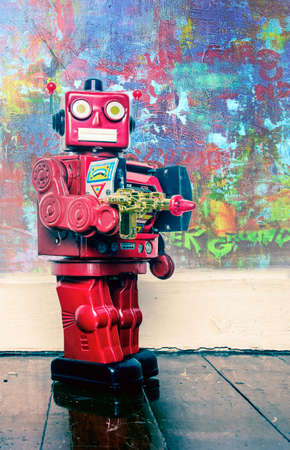 Soot them up a vintage robot with a ray gun on a wooden floor の写真素材