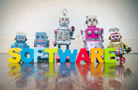 the word SOFTWARE made wit wooden letters  and robot toys on a wooden floor with copy spaceの写真素材