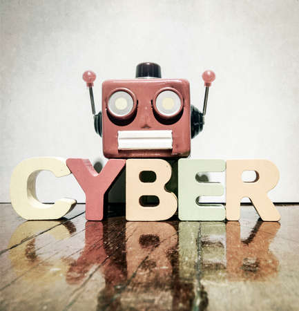 red retro robot head on the word   CYBER on old wooden florの写真素材