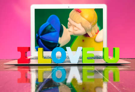 I LOVE U  with woden letters on a laptop on a wooden floorの写真素材