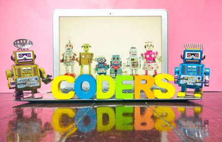 the word CODERS  with wooden letters on a laptop wit retro robot toys のeditorial素材
