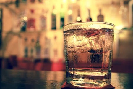 A glass of whiskey on the bar macro image の写真素材