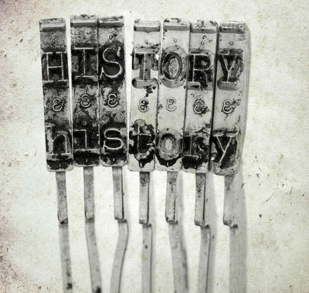 The word   HISTORY with old typewriter hammers  with old paper background macro imageの写真素材
