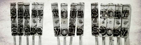 The words SHARE YOUR STORY with old typewriter hammers  with old paper background macro imageの写真素材