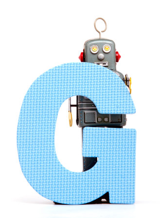capital letter G  held by vintage robot toysの写真素材