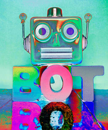 red robot head and the word BOT on a wooden floor with reflectionの写真素材