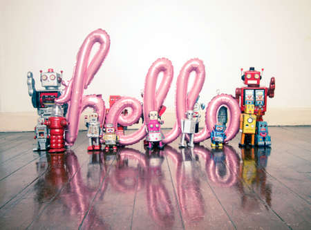 robots holding up the word hello on a old wooden floor with reflectionの写真素材