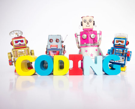a team of toy robots with the word coding isolated on white
