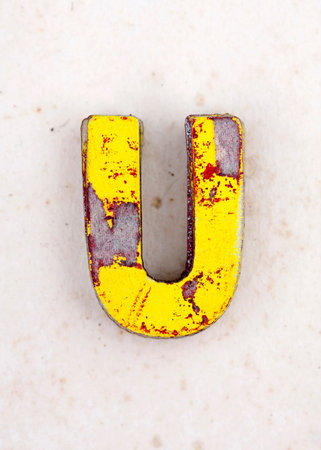 a pile of old  painted wooden letter U,s on old worn paper