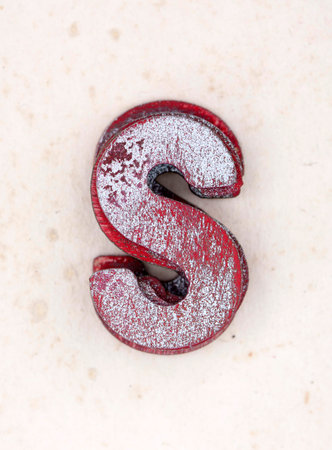 a pile of old  painted wooden letters S,s on old worn paperの写真素材