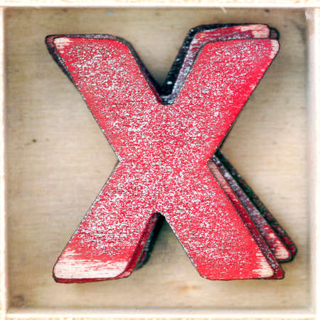 old wooden letter  X in a box shot from above macro imageの写真素材