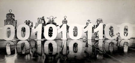 retro robots holding up 0 and 1,s binary code numbers on a old woooden floor solarized monochromeの写真素材