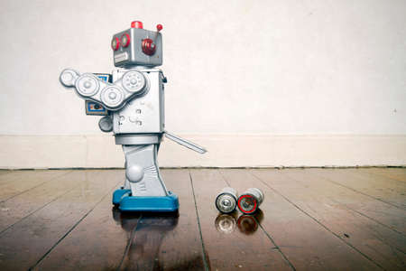 retro robot has a power failure  on a old wooden floorの写真素材