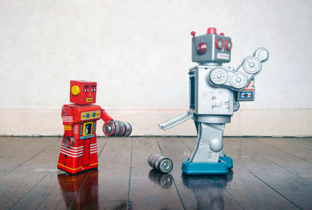 red robot helping big silver robot with a power problemの写真素材