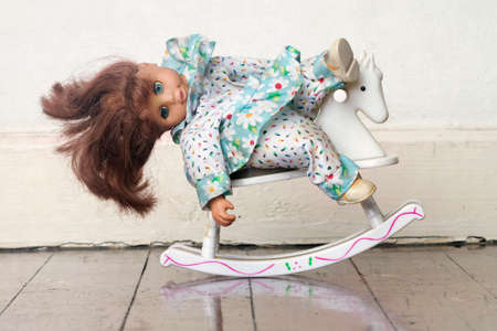 very  tired and sleepy old doll on a rocking horseの写真素材