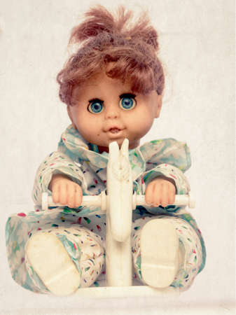old doll on a rocking horse  tone spooky image isolatedの写真素材